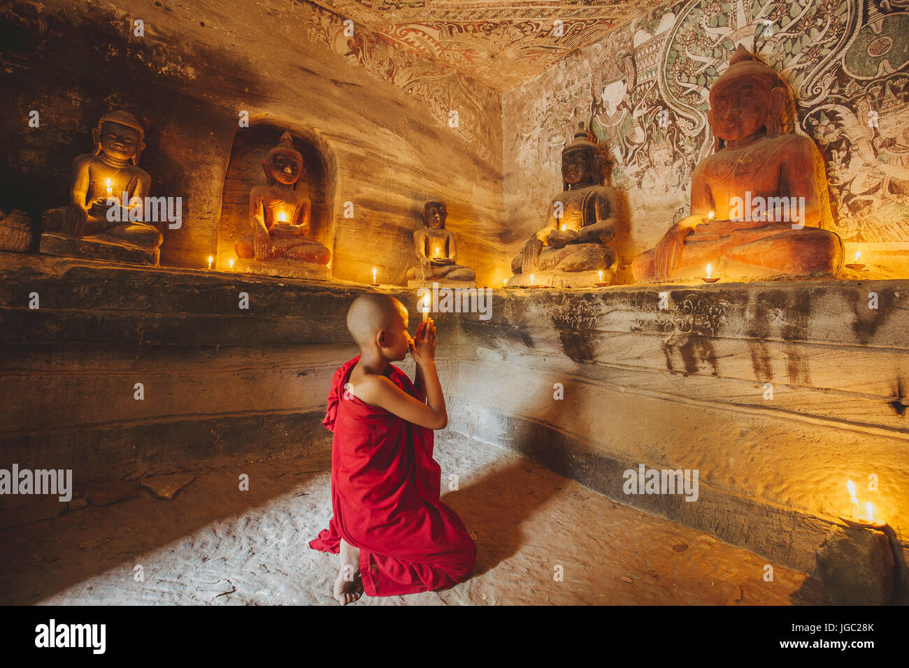 Monaco pregando con la luce di una candela in corrispondenza di Po Win Taung / grotta Hpowindaung - Monywa - Sagaing - Regione Nord del Myanmar Foto Stock