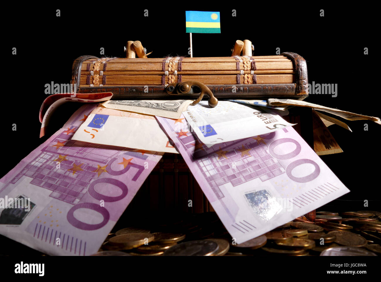 Bandiera ruandese sulla parte superiore della cassa piena di soldi Foto Stock
