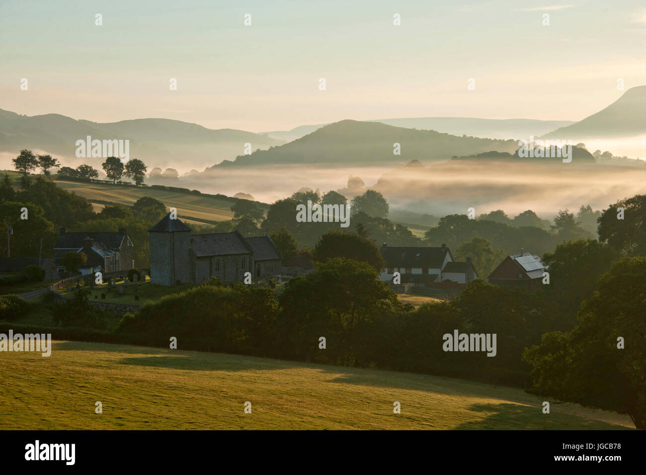 Llanddewi'r Cwm, Powys, Wales, Regno Unito. 5 Luglio, 2017. La nebbia avvolge il piccolo villaggio di Llanddewi'r Cwm in Powys, Wales, Regno Unito. a sunrise. Credito: Graham M. Lawrence/Alamy Live News Foto Stock