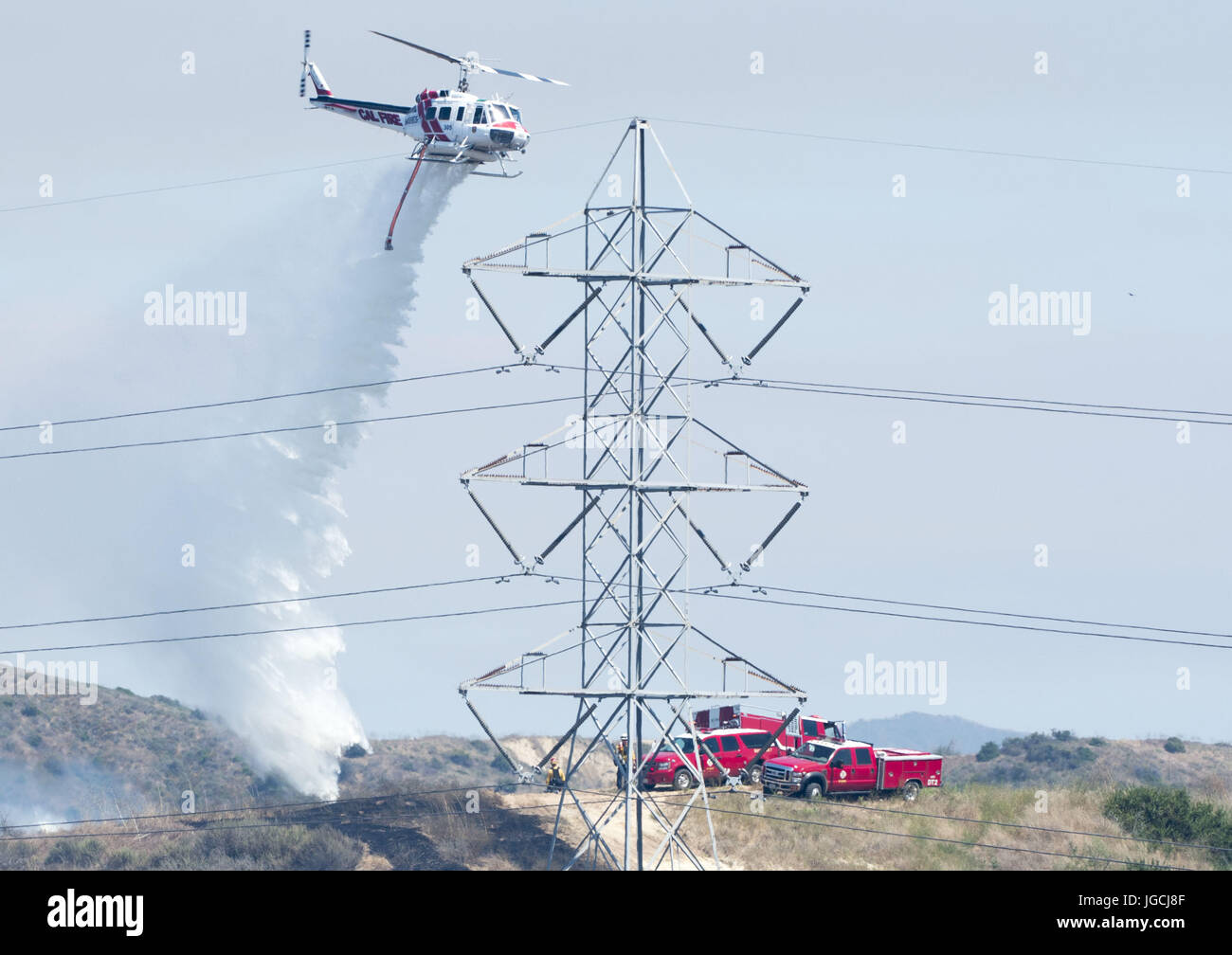 San Clemente/Talega, California, Stati Uniti d'America. 5 Luglio, 2017. Un elicottero OCFA rende una goccia di acqua lungo la linea di fuoco. Til Orange County Fire competente ha risposto a 25 acri di vegetazione fire mercoledì pomeriggio alla fine di Avenida Pico a San Clemente. Il OCFA è stata assistita da Cal fuoco come pure i vigili del fuoco da Camp Pendleton. Circa 100 i vigili del fuoco hanno attaccato le fiamme in terreno collinare con l aiutante di due Cal Fire su aerei ad ala fissa nonché elicotteri da Cal Fire e la OCFA. Credito: ZUMA Press, Inc./Alamy Live News Foto Stock