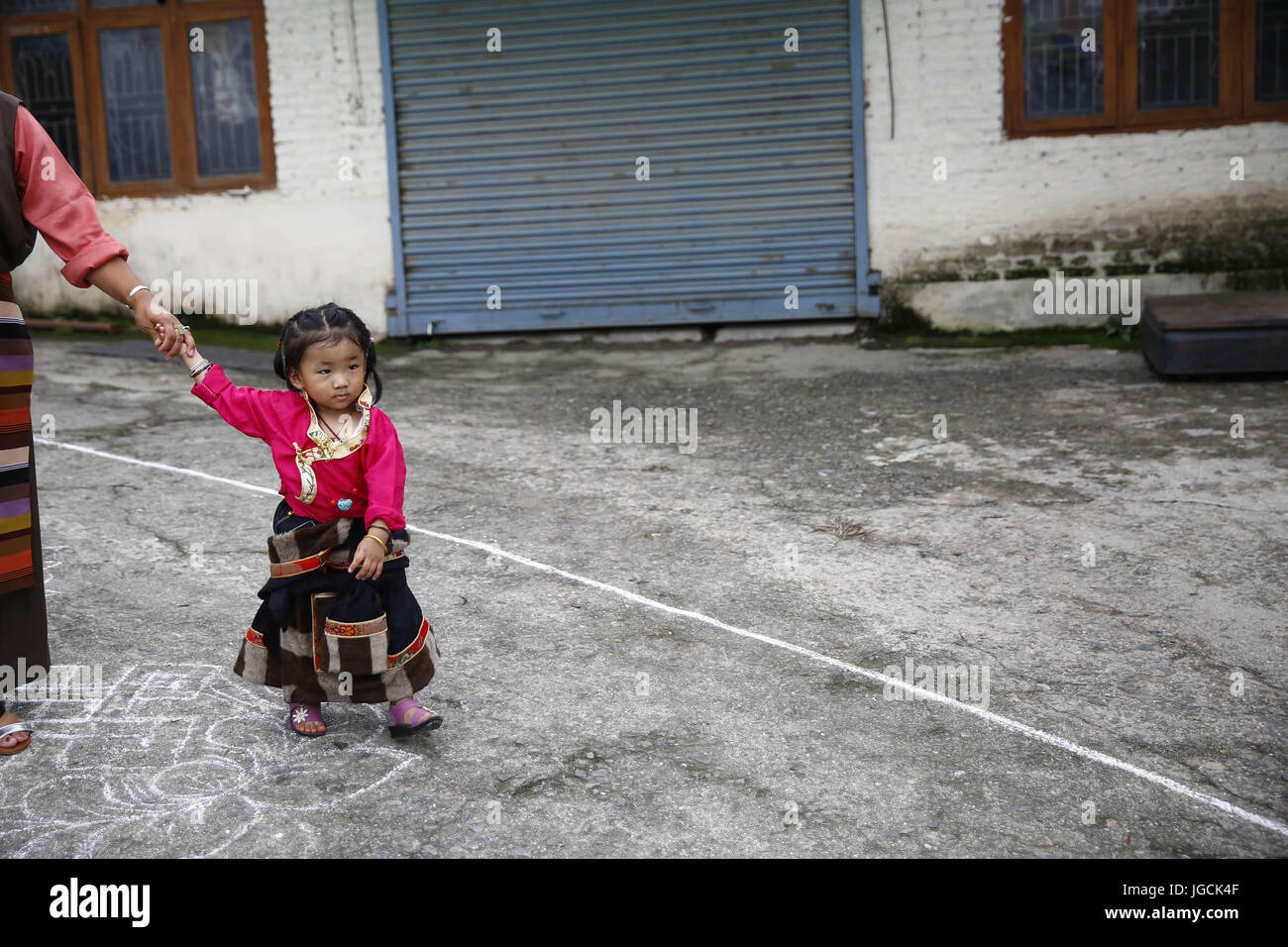 Lalitpur, Nepal. 6 Luglio, 2017. Una ragazza tibetana passeggiate lungo la sua madre durante l'ottantaduesima festa di compleanno di Sua Santità il Dalai Lama in Lalitpur, Nepal giovedì 6 luglio, 2017. Credito: Skanda Gautam/ZUMA filo/Alamy Live News Foto Stock