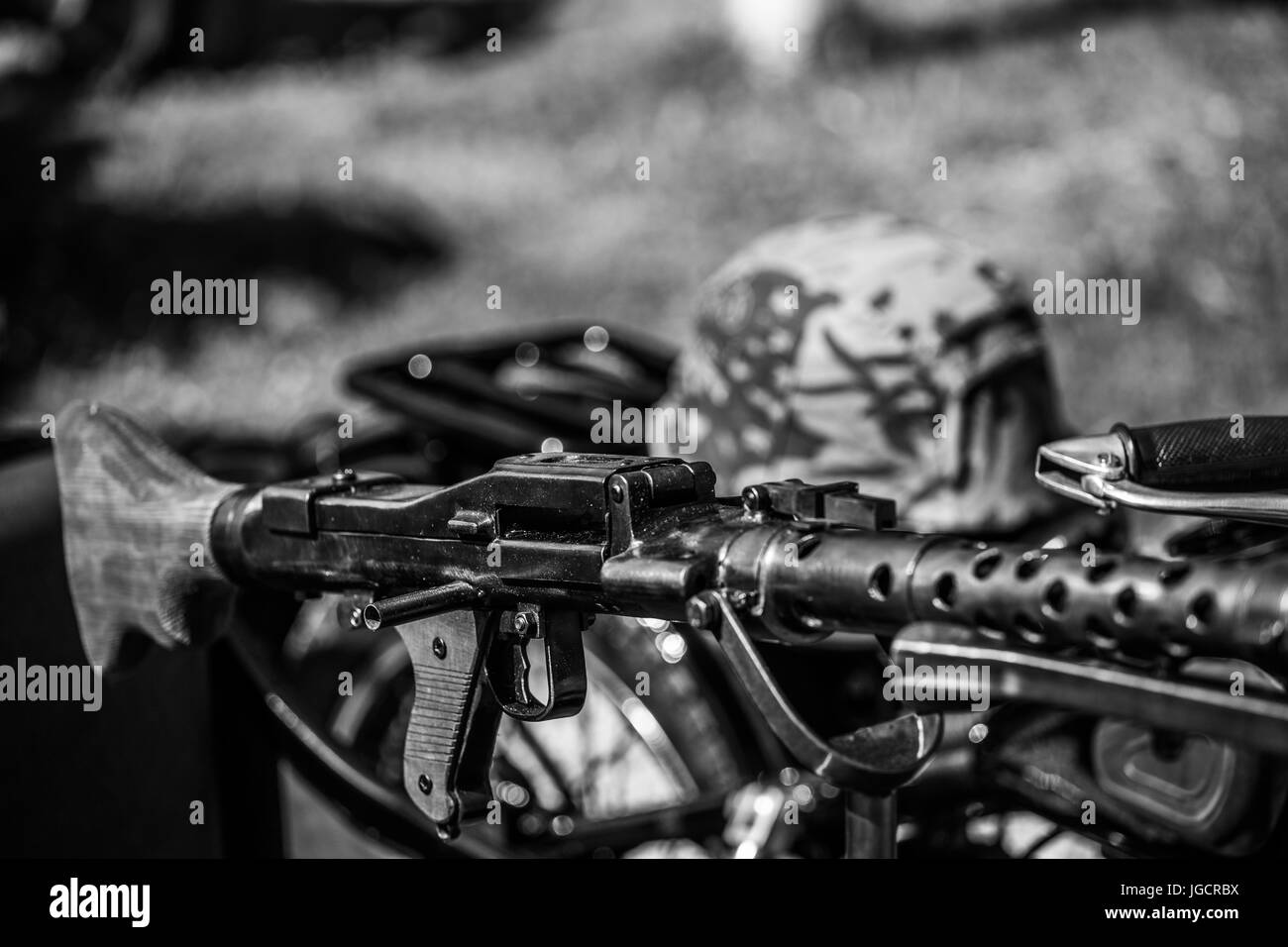 Fucile giocattolo () su una vecchia motocicletta BMW R71 da guerra mondiale dopo il rinnovo con cappello militare in background. In bianco e nero. Foto Stock