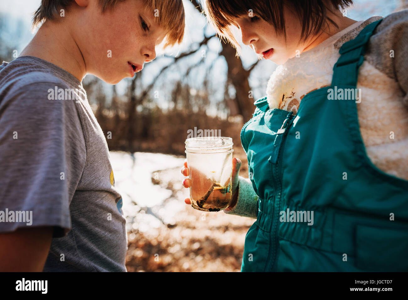 Un ragazzo e una ragazza tenendo un vaso con acqua bug Foto Stock