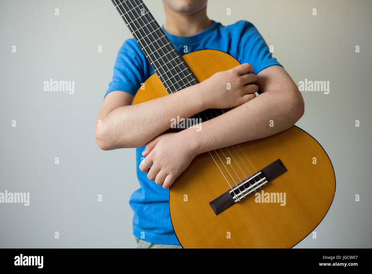 Ragazzo che abbraccia la sua chitarra Foto Stock