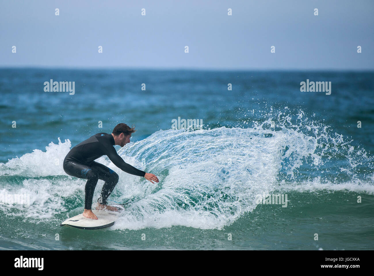 Surf UK; un surfista cavalca un wave a Fistral in Newquay, Cornwall. Foto Stock