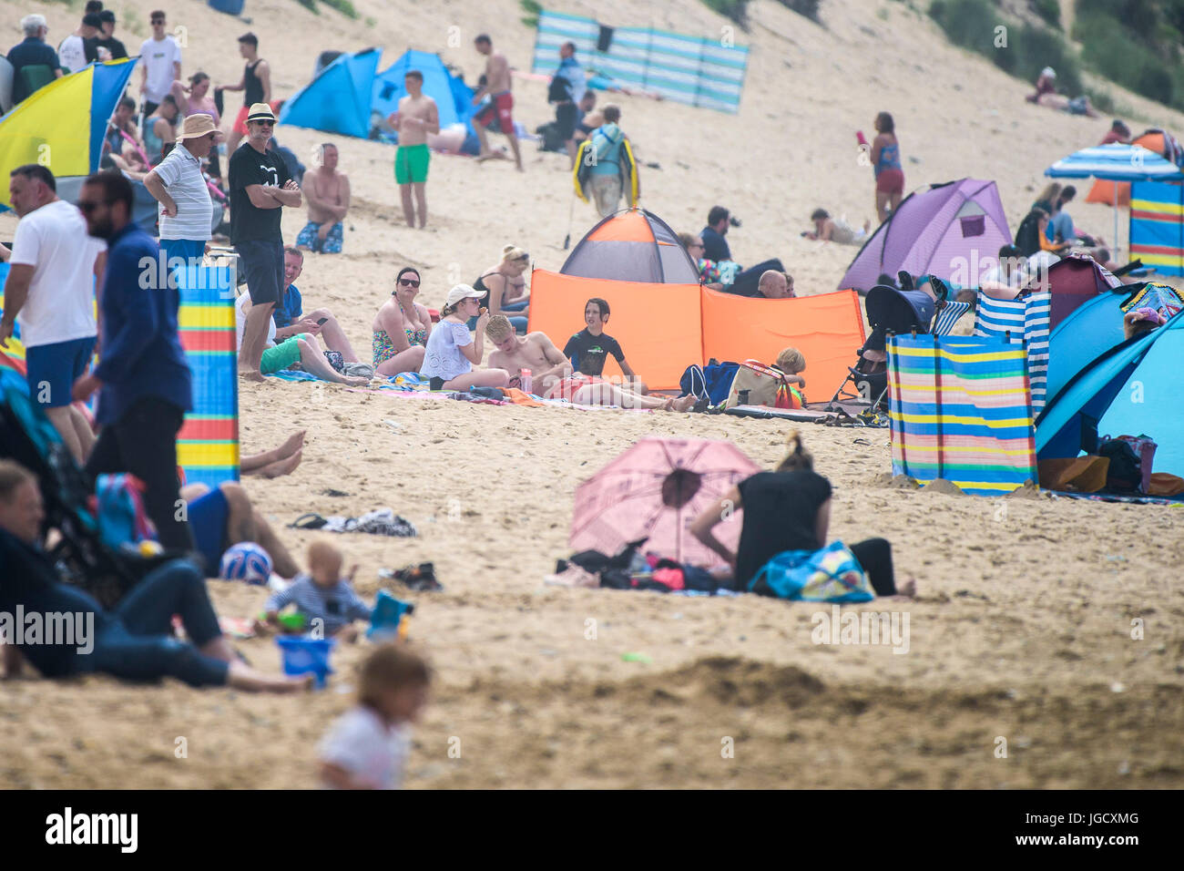 Persone su una spiaggia. Vacanzieri relax su Fistral Beach in Newquay, Cornwall. Foto Stock