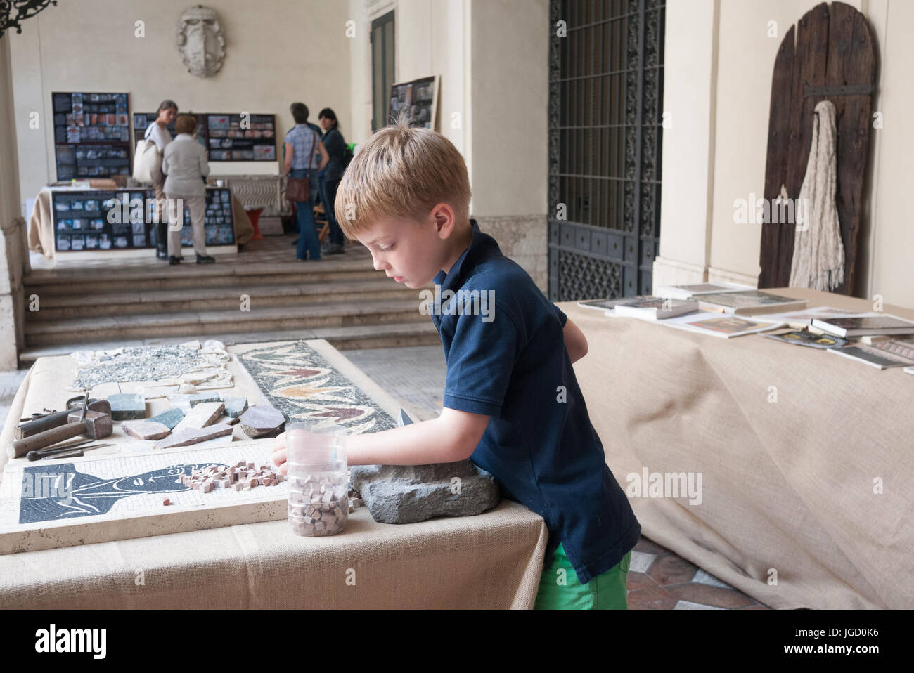 I bambini a imparare a fare un mosaico di pietra Foto Stock