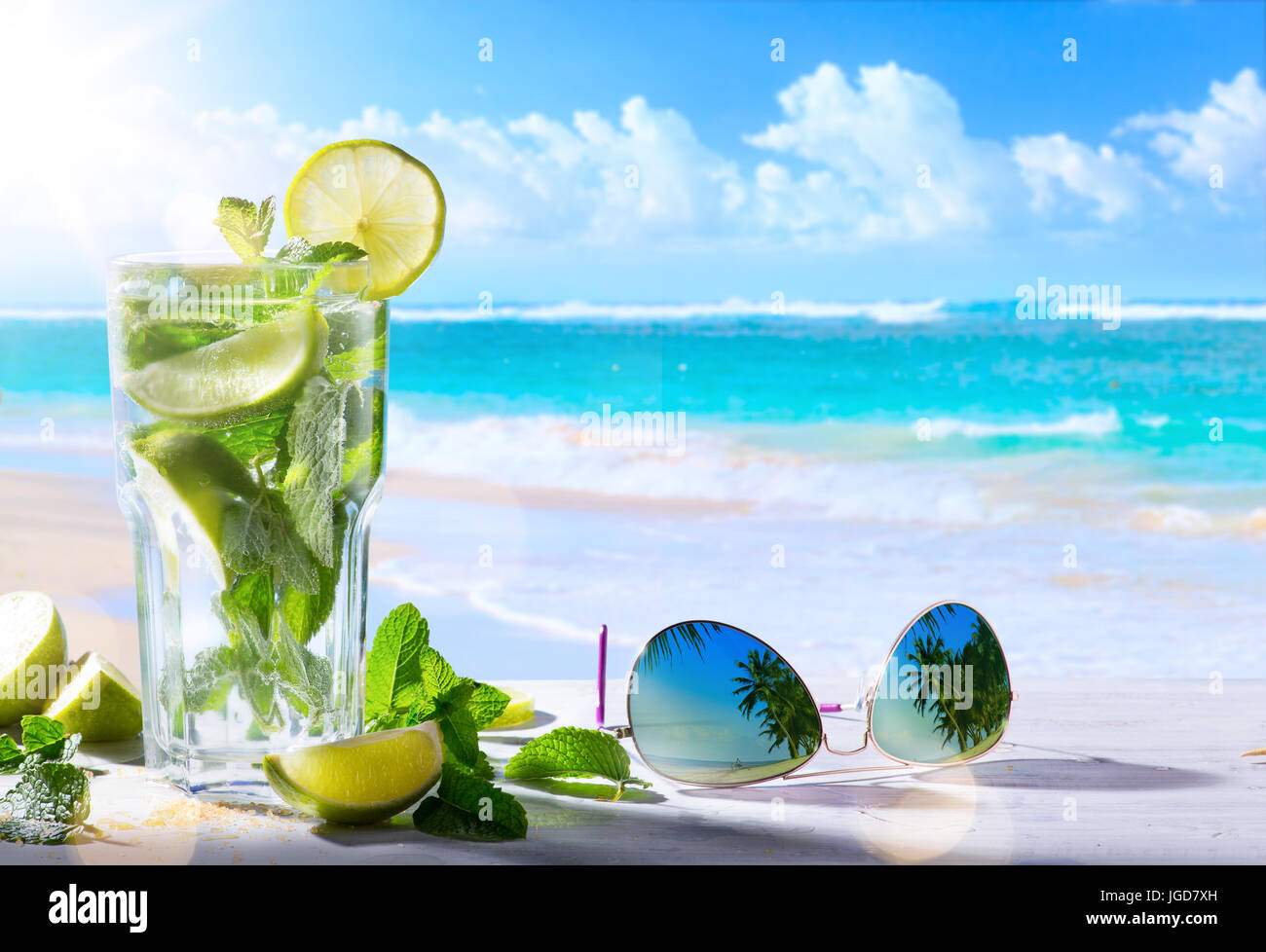 Tropico vacanza estiva; drink esotici sulla sfocatura spiaggia tropicale sfondo Foto Stock