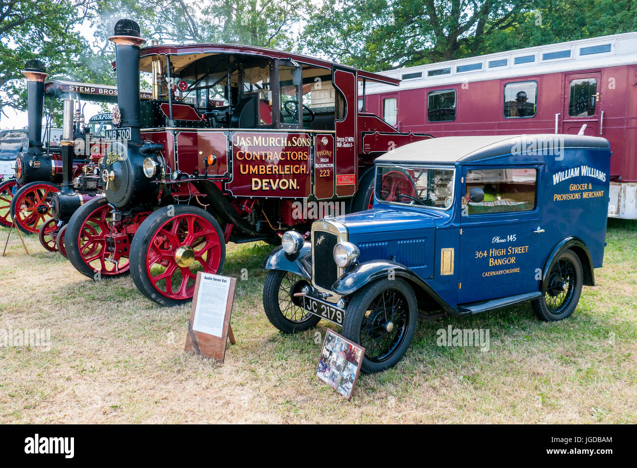 Agricola i motori di trazione lungo il lato di una Austin sette vintage furgone commerciale in un rally a vapore Foto Stock