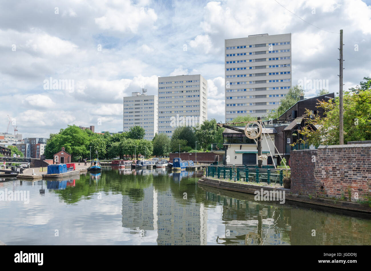 Narrowboats sul canale in esecuzione attraverso Birmingham al posto Danielle con elevato aumento di blocchi di appartamenti in background Foto Stock