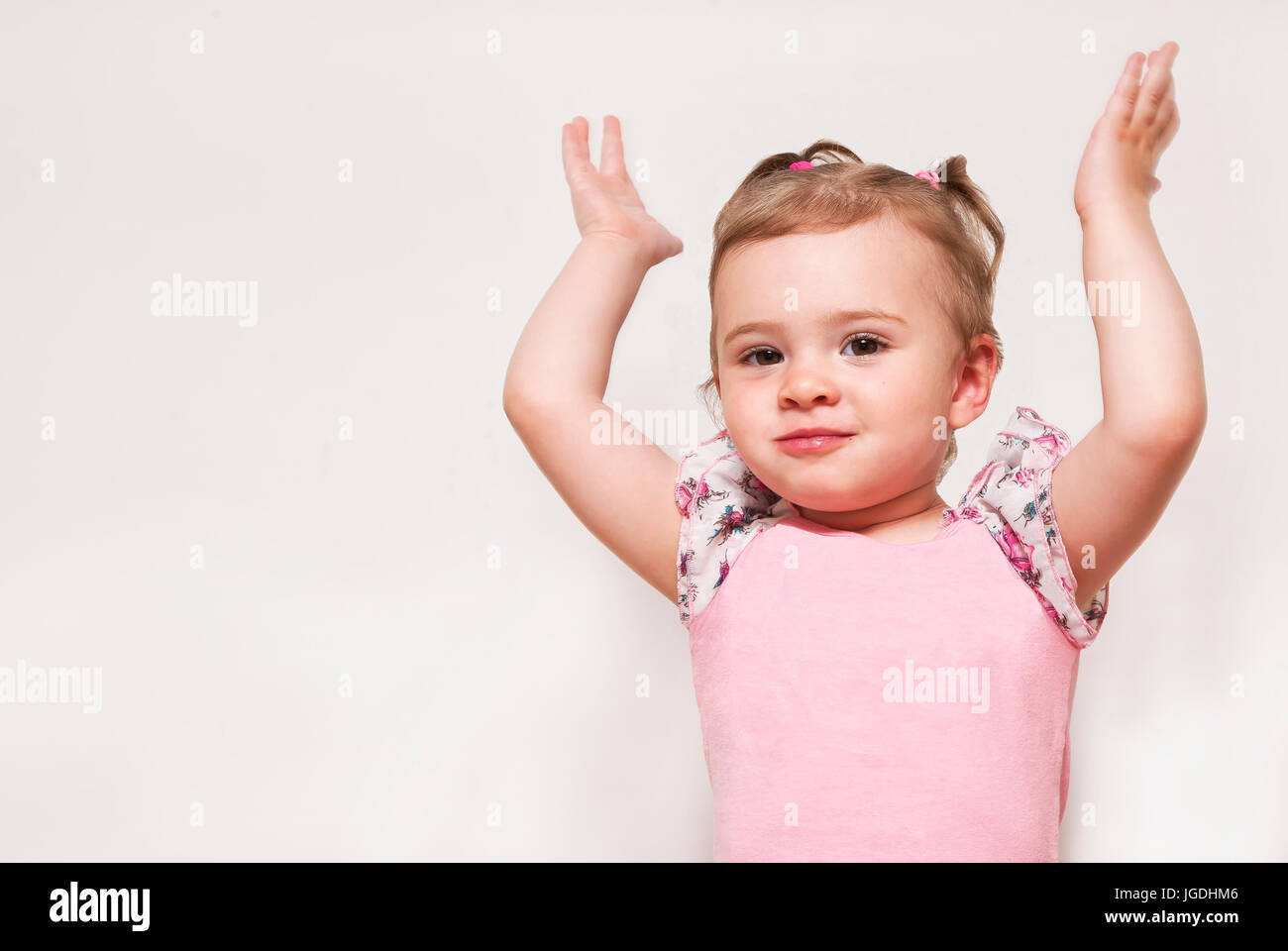 Ritratto di un simpatico baby con il sollevamento in alto le mani Foto Stock