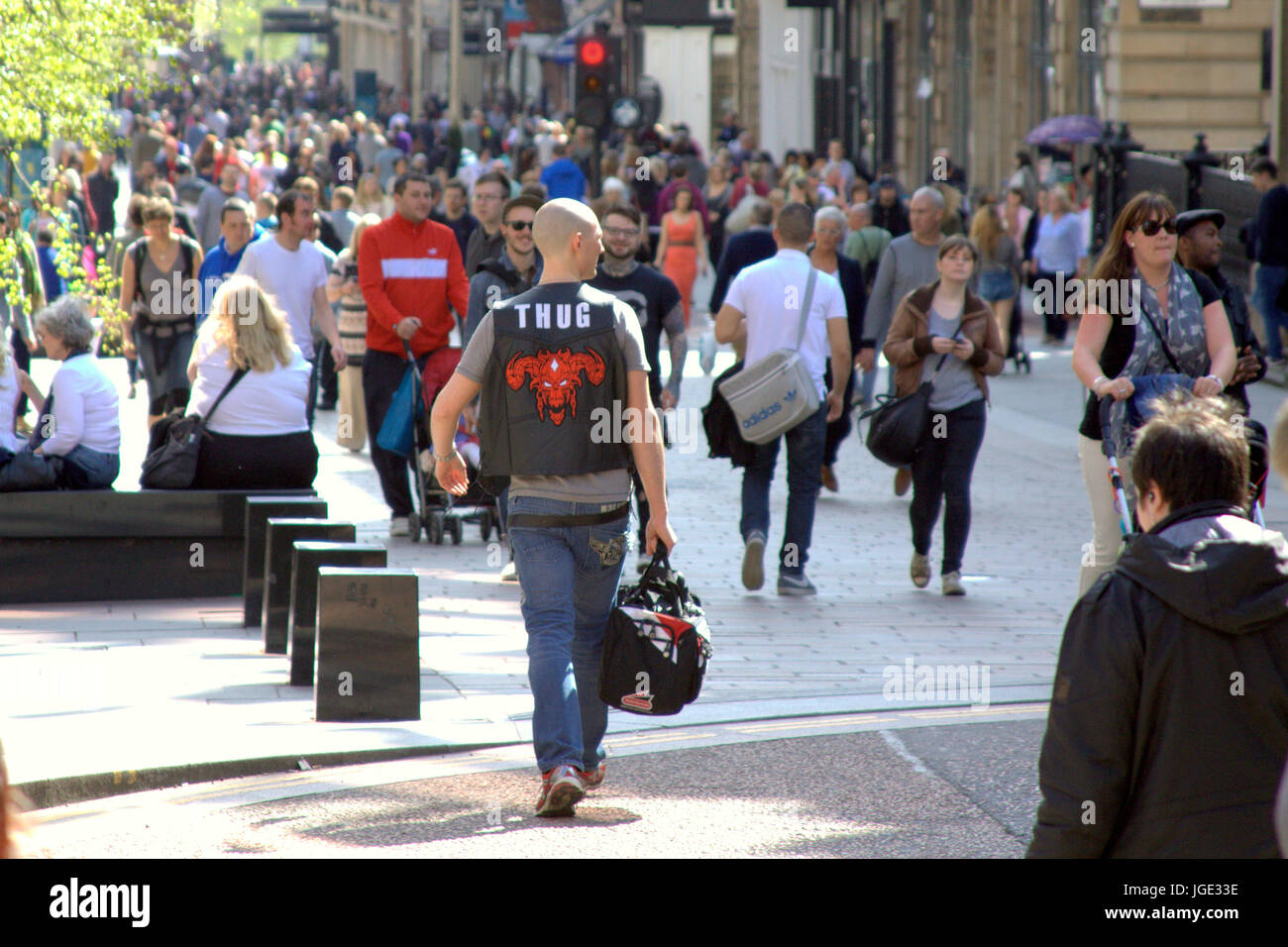 Strada di Glasgow Buchanan Street shoppers thug giacca bikers design emblema giornata di sole Foto Stock