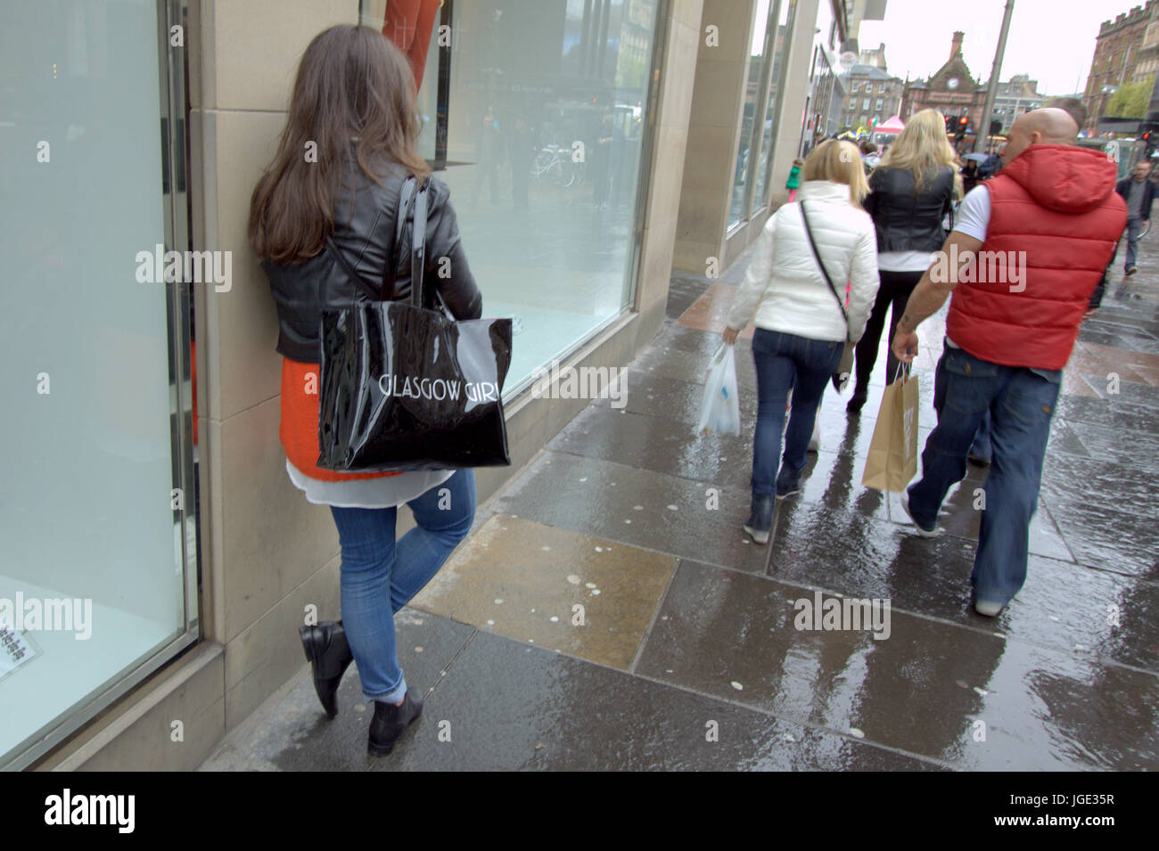 Strada di Glasgow Buchanan Street shoppers Glasgow ragazza adolescente sacco appoggiata contro la parete Foto Stock
