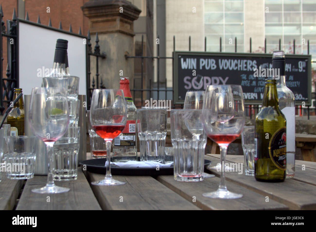 Discoteca pub club casa pubblica la tabella con bevande bicchieri e bottiglie vino birra sidro vuoto ubriaco di tavoli in legno Foto Stock