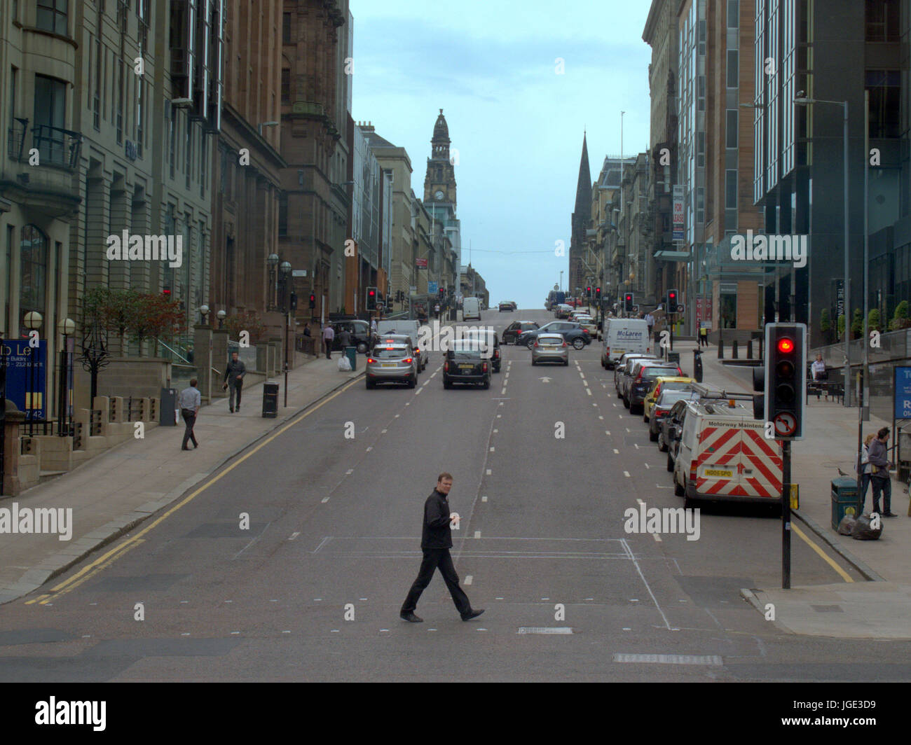 Uomo maschio attraversamento pedonale strada al semaforo St Vincent Street Glasgow guardando ad ovest Foto Stock