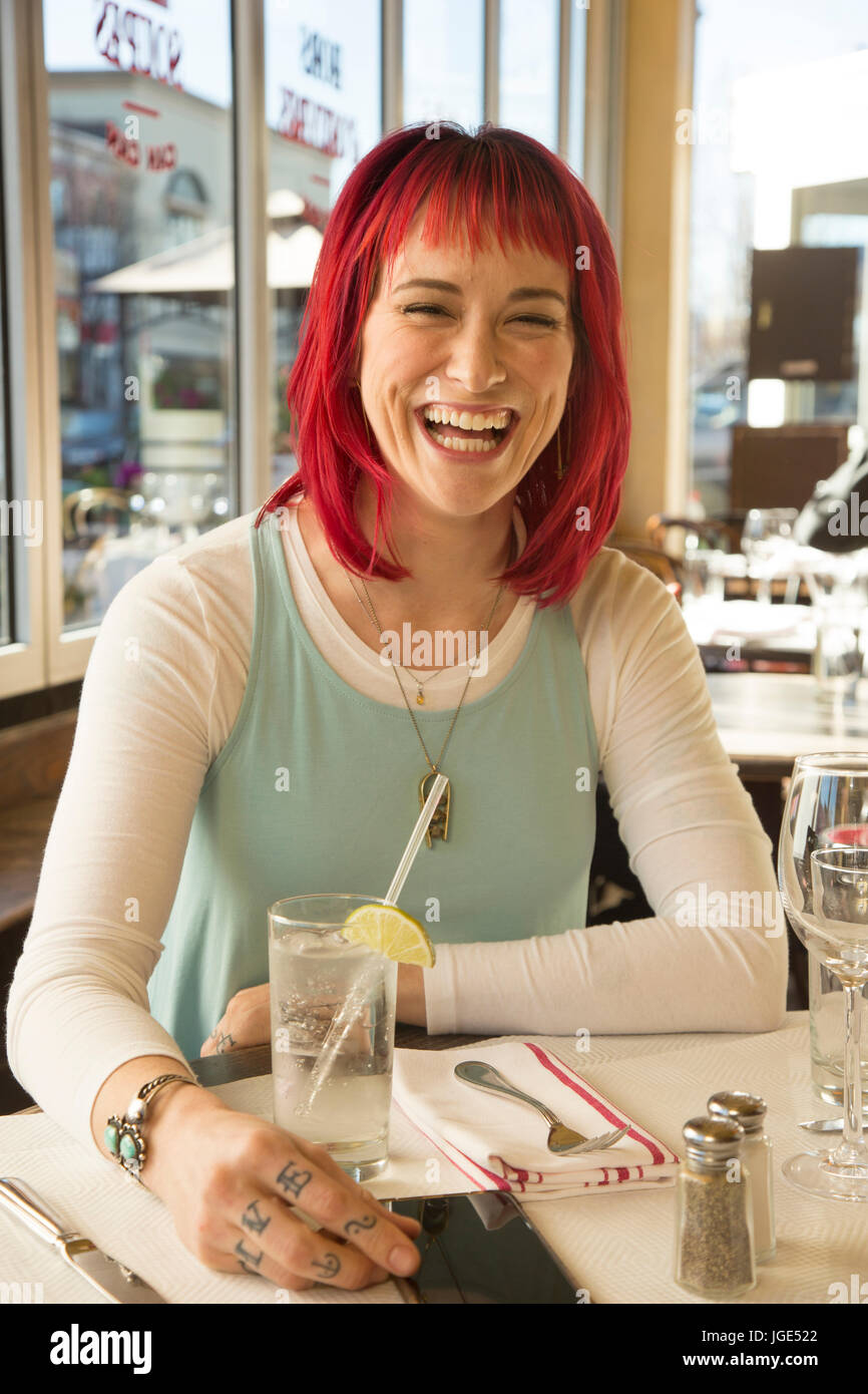 La donna caucasica ridere in ristorante Foto Stock