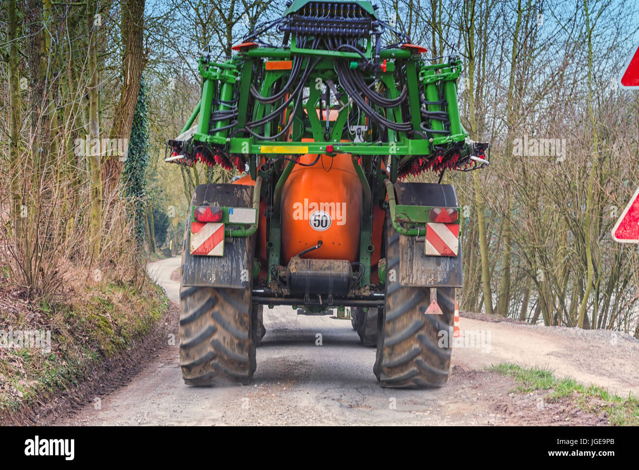 Trattore con macchina agricola di irrorazione di fertilizzanti o insetticidi su un campo. Foto Stock