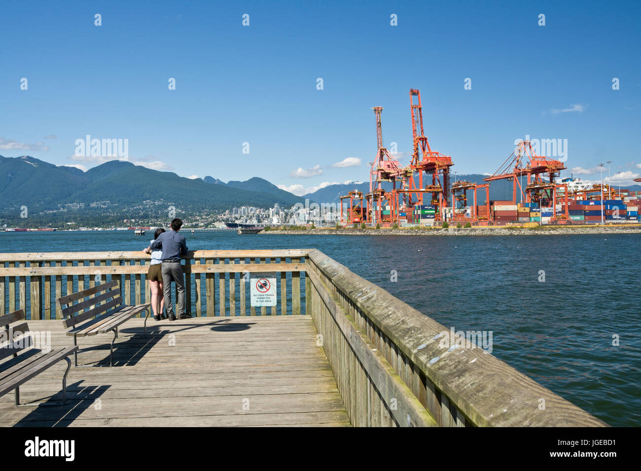 Giovane guardando l'acqua e montagne del porto di Vancouver sul molo al Parco di granchio al waterfront. Burrard ingresso. Foto Stock