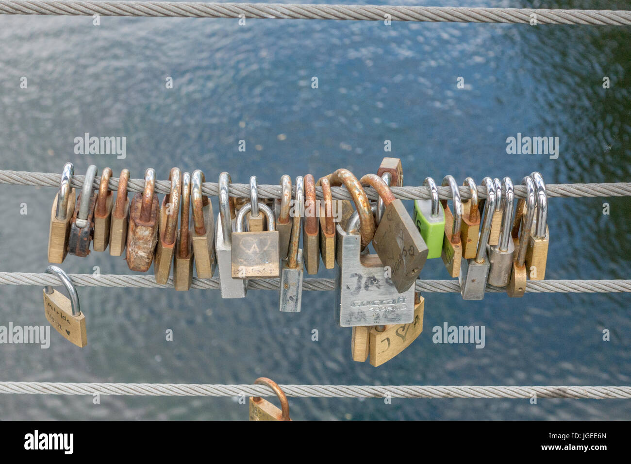 Lucchetti sul lato di un ponte, fili di sicurezza Foto Stock