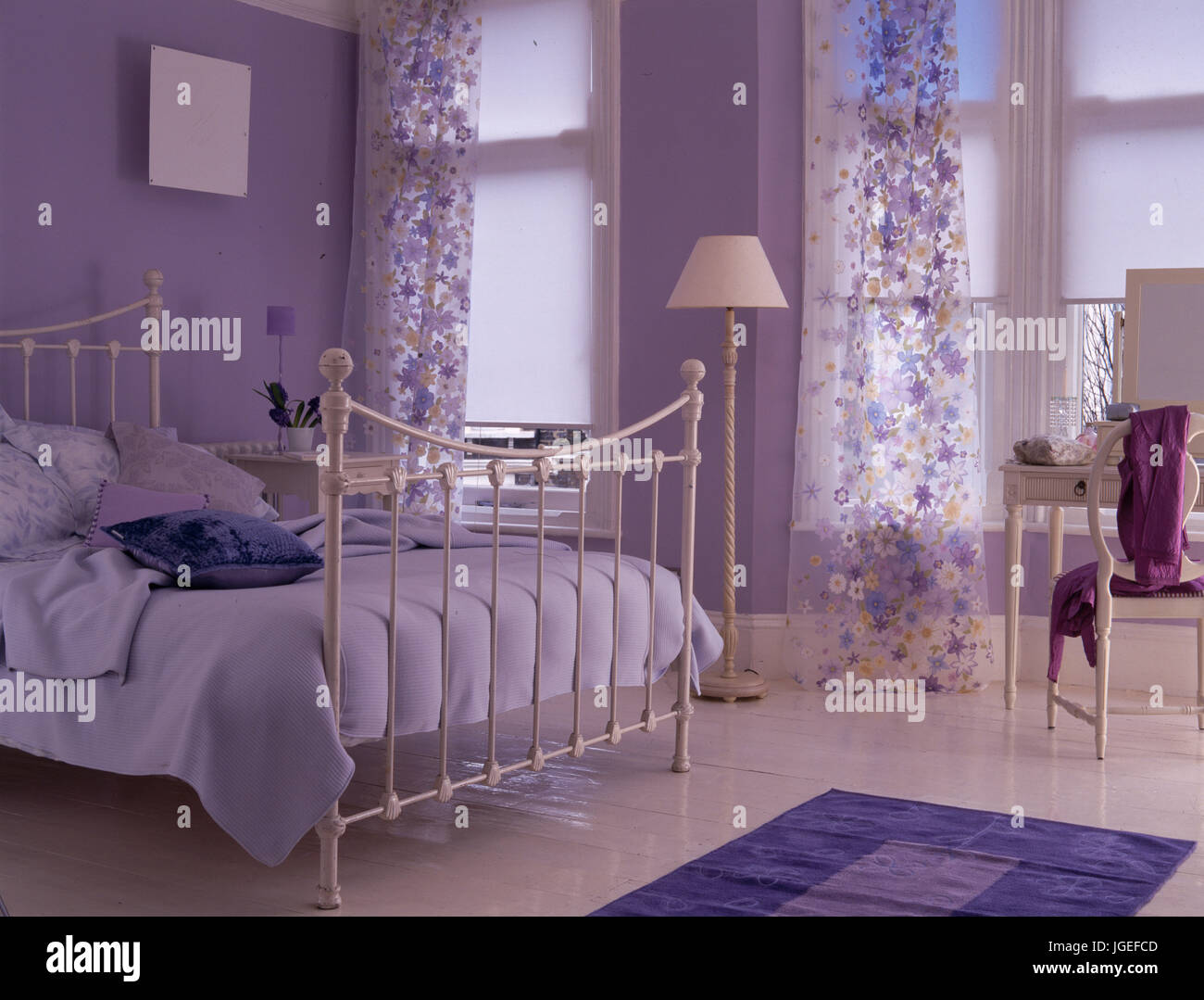 Malva di camera da letto matrimoniale con il bianco letto di ferro battuto e tende di voile Foto Stock