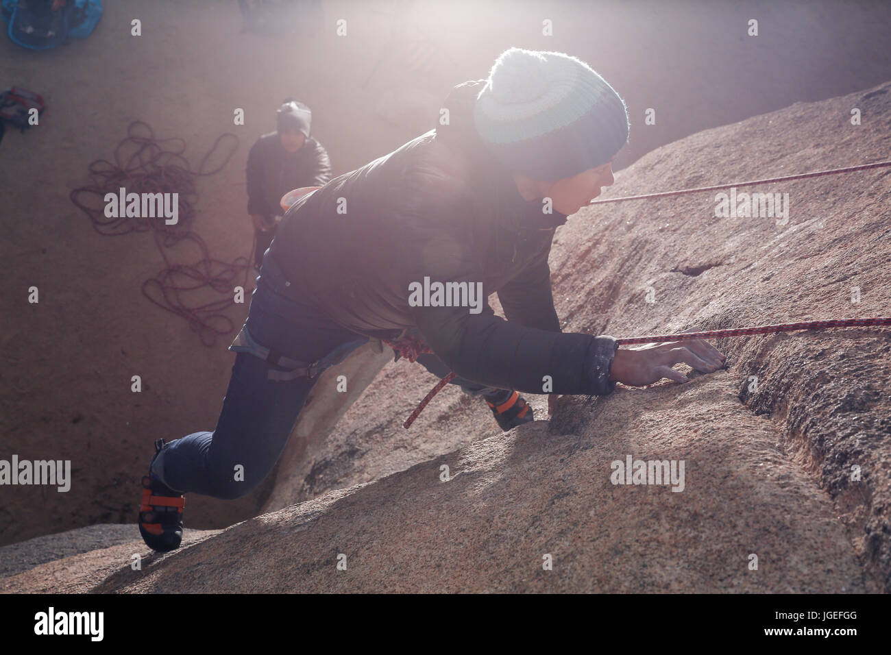 Giovani razza mista donna arrampicata su roccia nel deserto Foto Stock