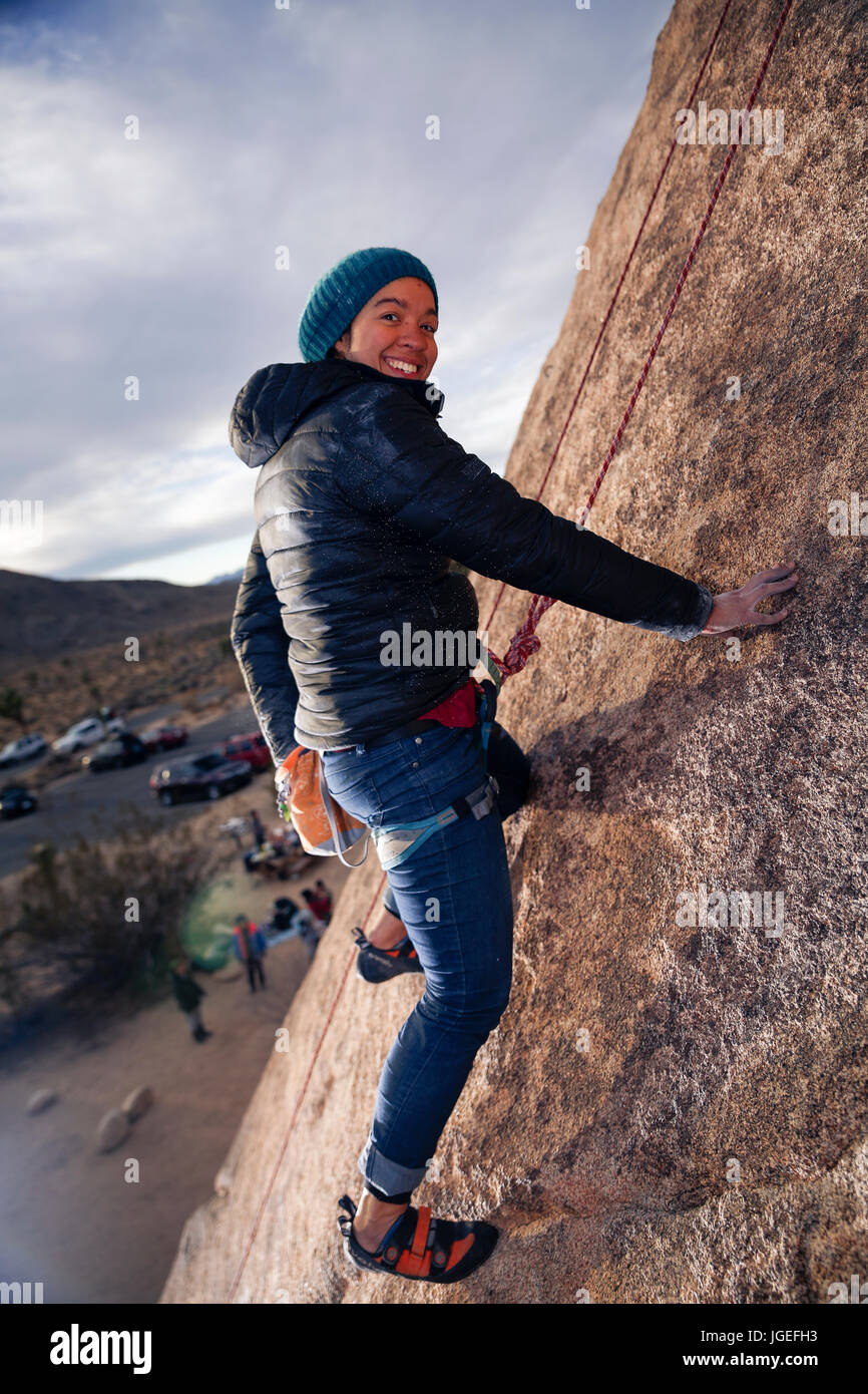 Giovani razza mista donna arrampicata su roccia nel deserto Foto Stock