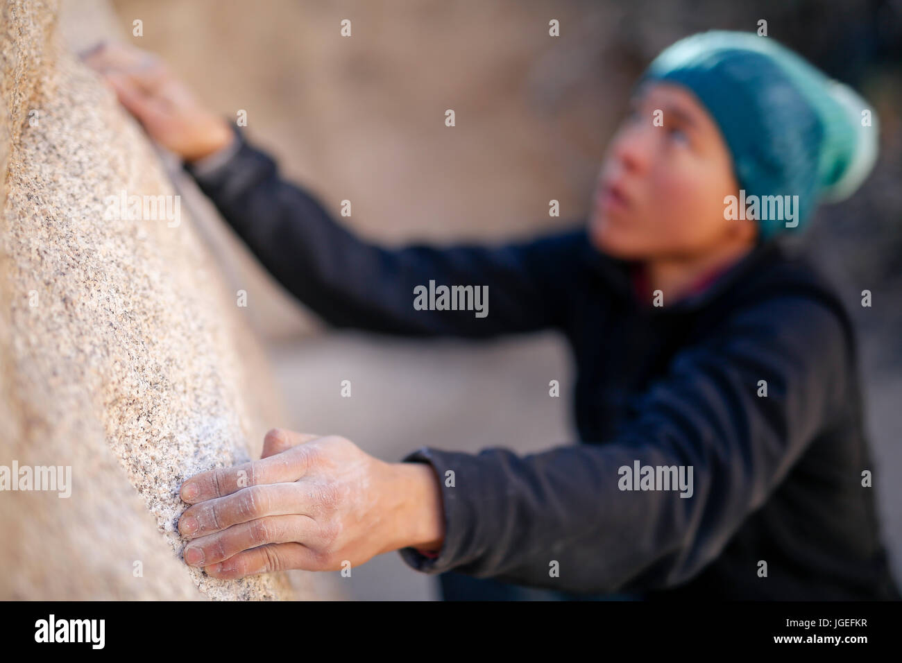Giovani razza mista donna vestita di freddo di abbigliamento rock si arrampica nel deserto Foto Stock