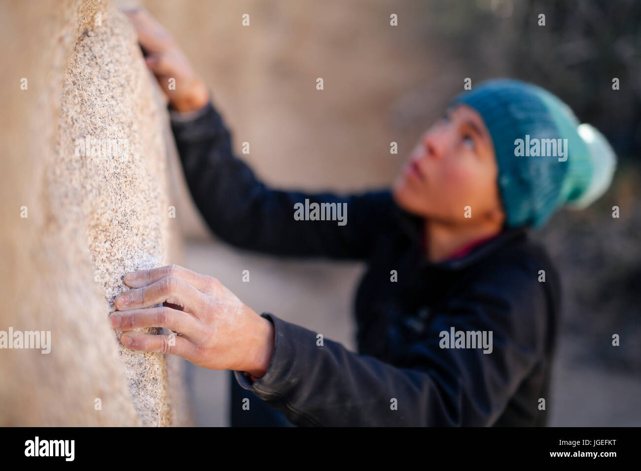 Giovani razza mista donna vestita di freddo di abbigliamento rock si arrampica nel deserto Foto Stock