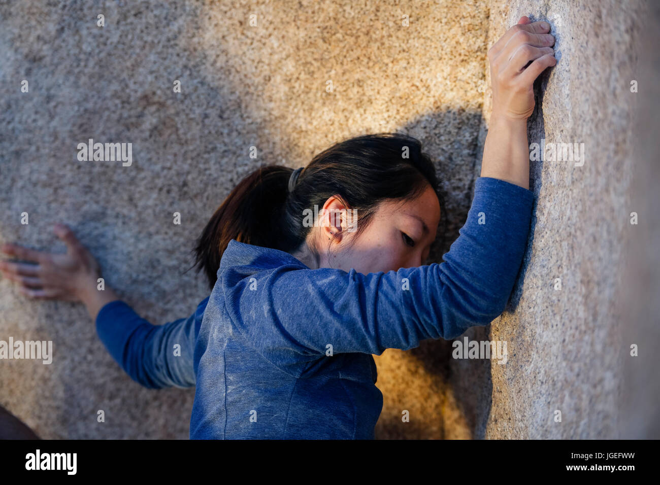 Giovane donna asiatica rock si arrampica nel deserto con nessuna attrezzatura di sicurezza Foto Stock