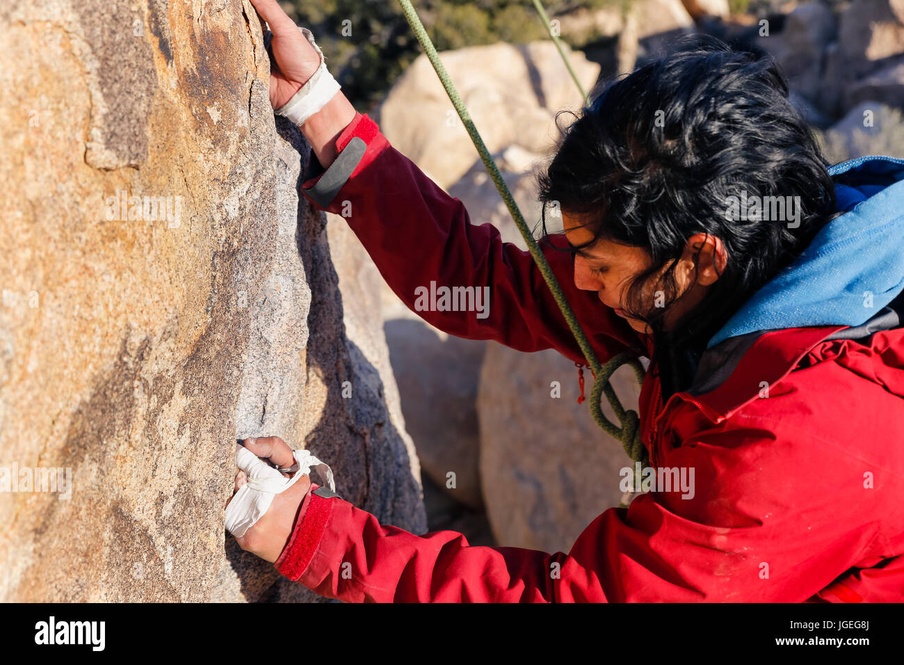 South Asian giovane donna arrampicata su roccia nel deserto Foto Stock