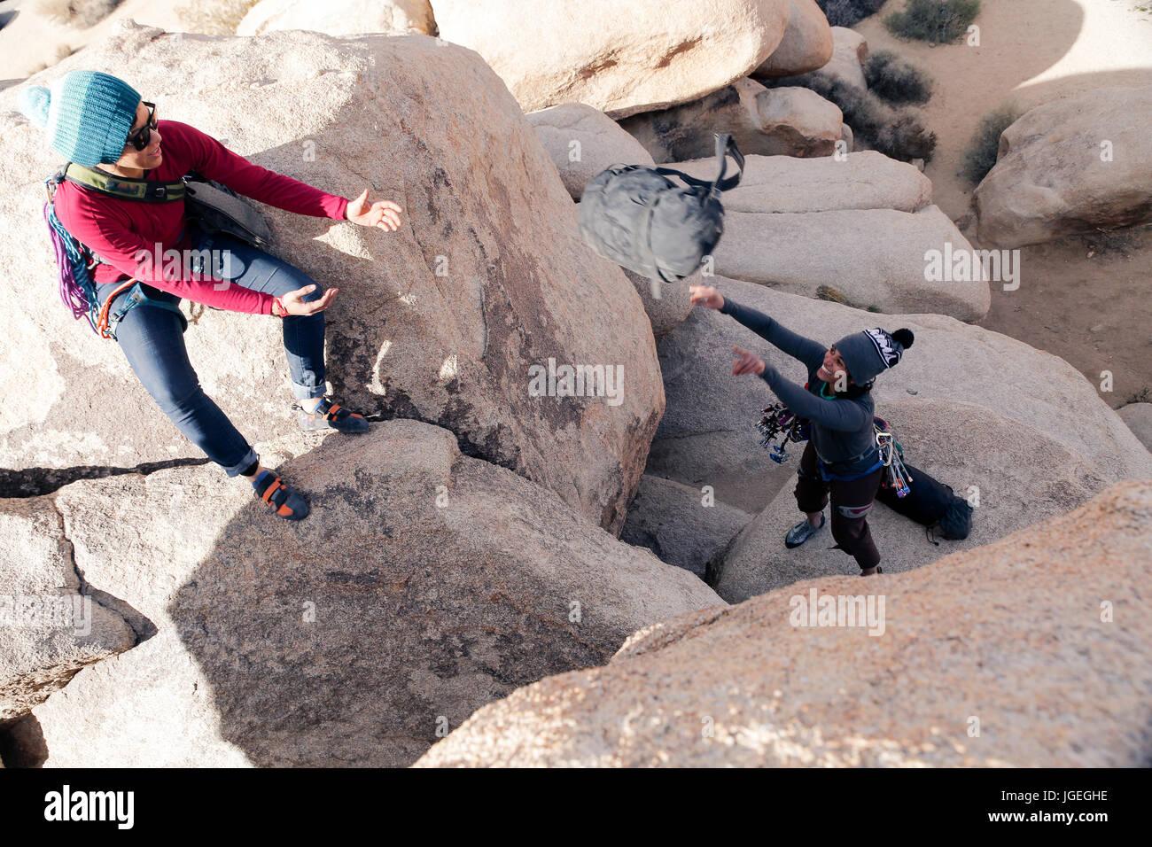 Due giovani donne di razza mista aiutare reciprocamente durante la scalata su roccia nel deserto Foto Stock