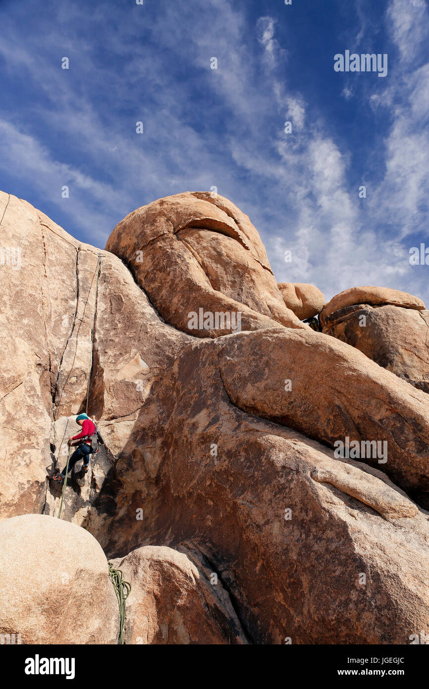 Giovani razza mista donna rock si arrampica nel deserto con attrezzatura tecnica mentre vestita per basse temperature Foto Stock