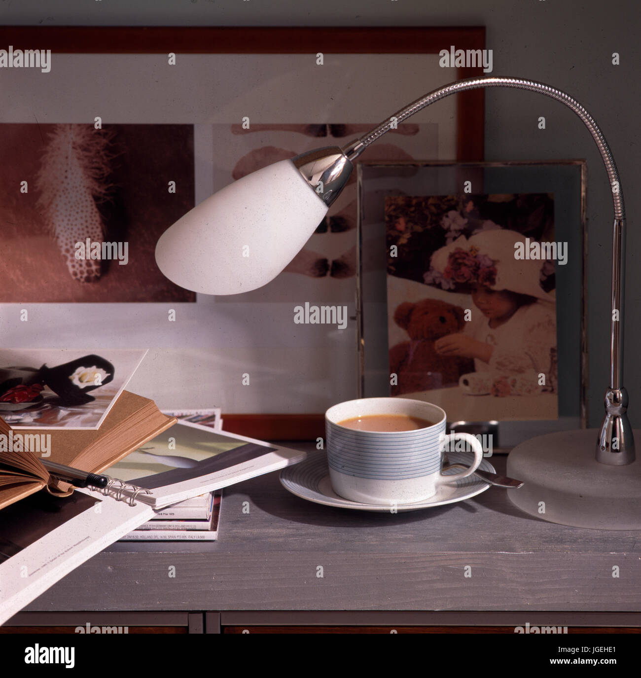 Dettaglio della scrivania con tazza di tè opf e lampada Foto Stock
