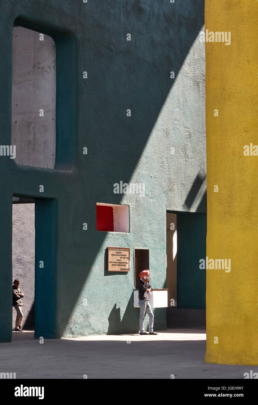 Le figure appoggiata contro le pareti colorate con forte ombra. Il Palazzo di Giustizia, chandigarh, India. Architetto: Corbusier, 1955. Foto Stock