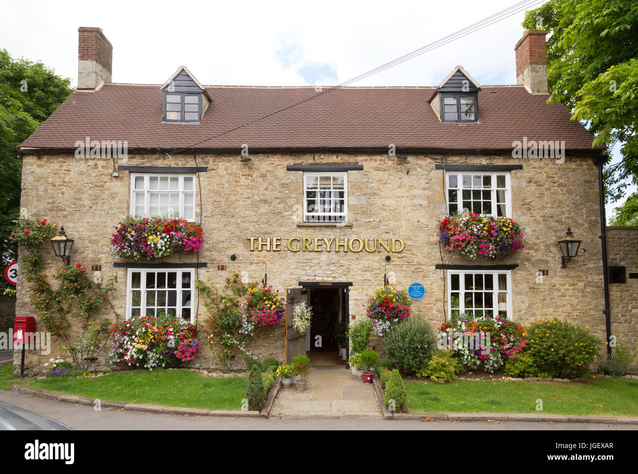The Greyhound Pub, Wooton, Oxfordshire in estate con fiori e nei cestini appesi; Oxfordshire England Regno Unito Foto Stock