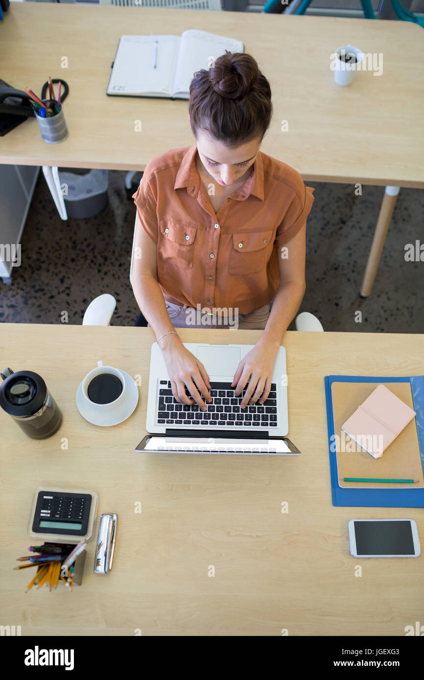 Femmina di dirigenti che lavorano su computer portatile alla sua scrivania in ufficio Foto Stock