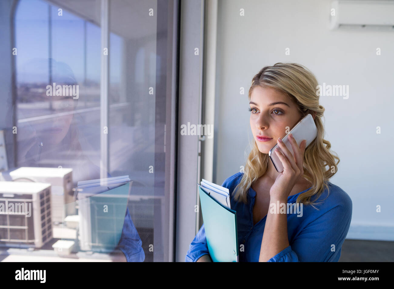 Executive femmina parlando al telefono cellulare in ufficio Foto Stock