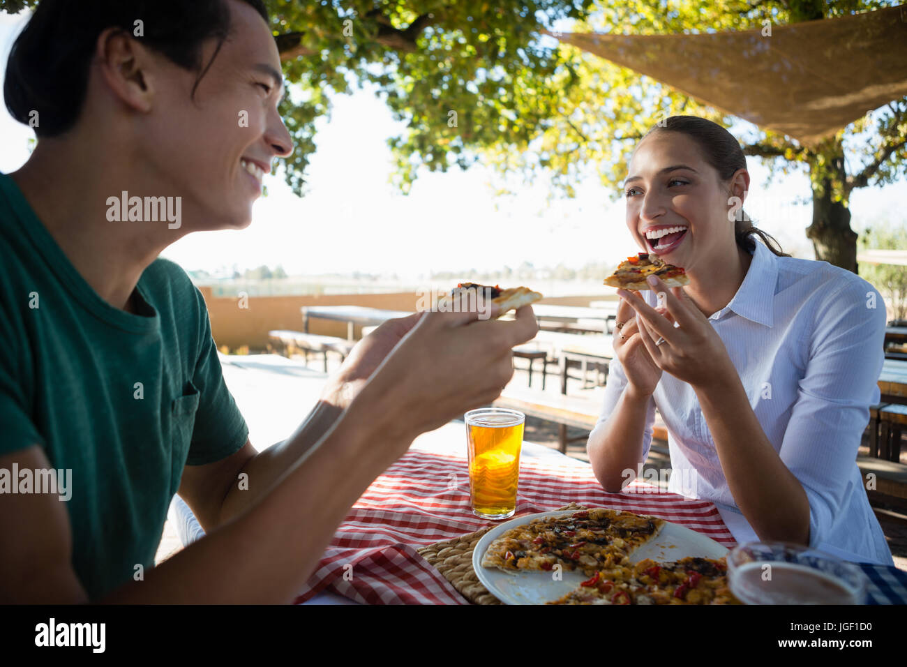 Happy amici avente pizza al ristorante all'aperto Foto Stock