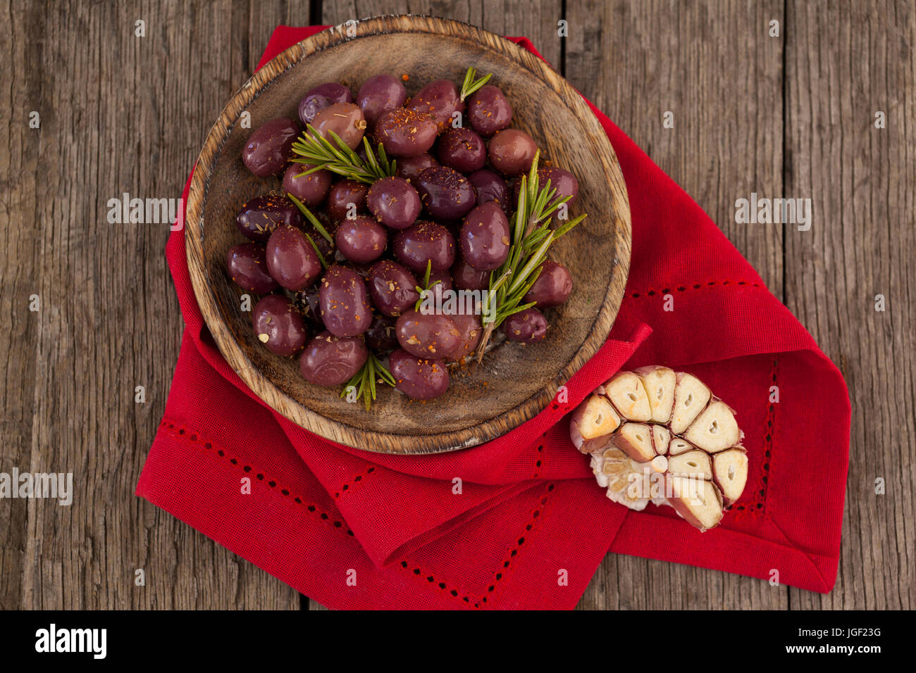 Vista aerea di olive con rosmarino in vaso sul tovagliolo rosso Foto Stock