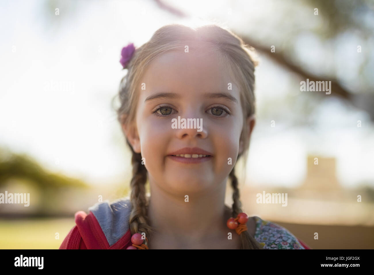Ritratto di incantevole piccola ragazza sorridente in telecamera in una giornata di sole Foto Stock