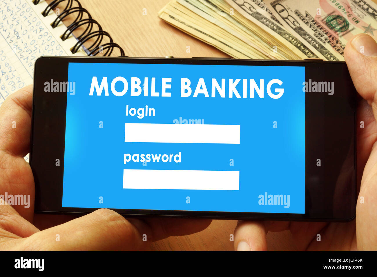 Mani tenendo il telefono con la pagina mobile banking. Il pagamento on-line concept. Foto Stock
