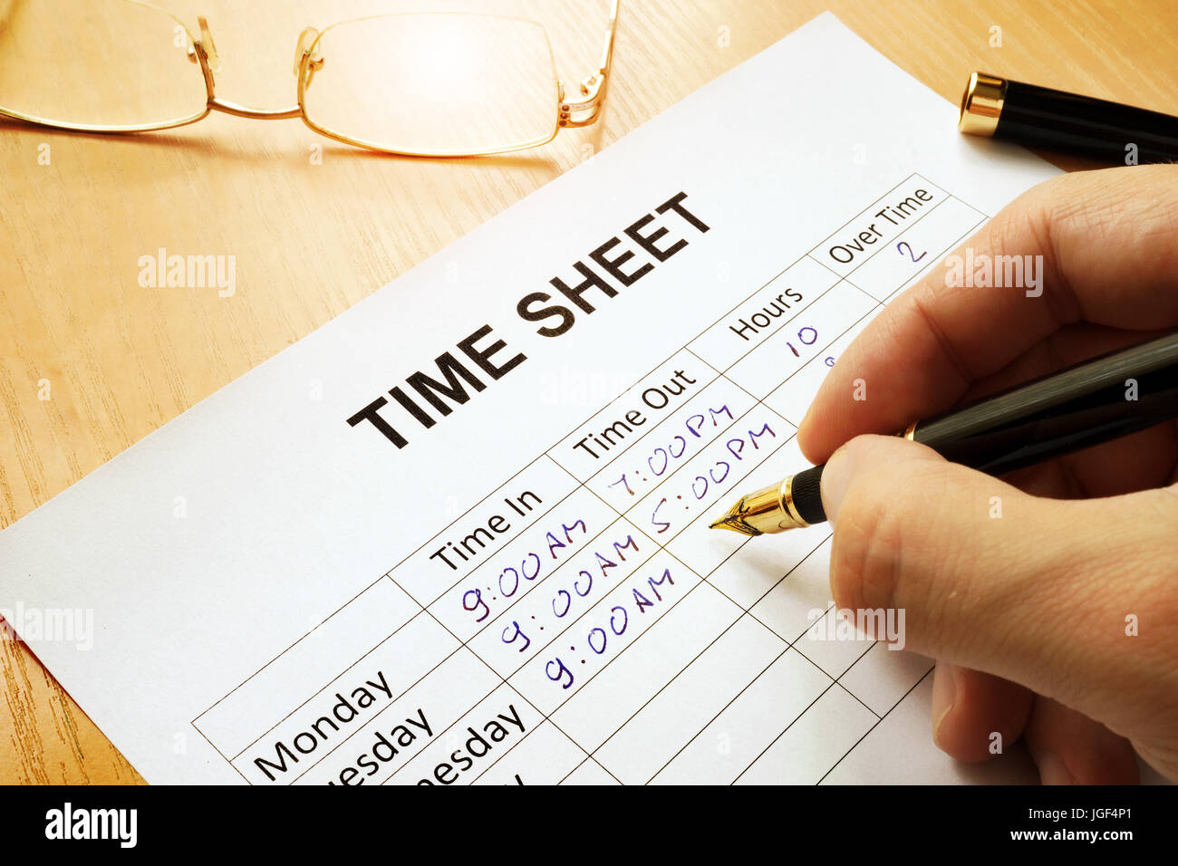 Registra le ore di lavoro in un momento in foglio. Foto Stock