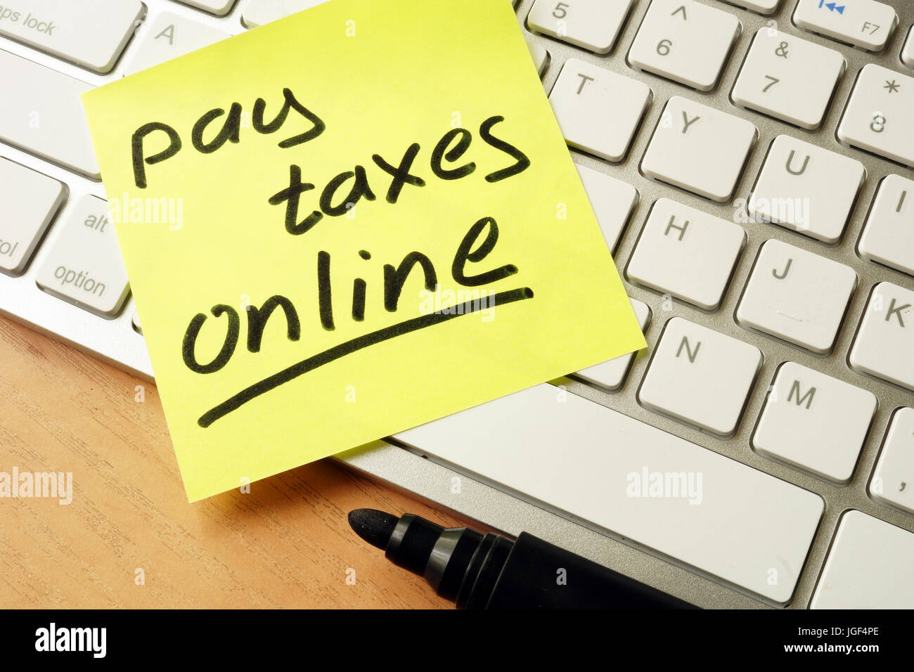 Memo stick con parole di pagare le tasse online. Foto Stock
