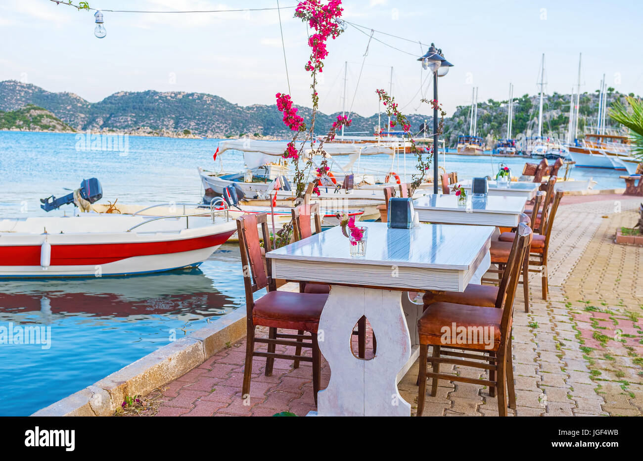 L'accogliente terrazza del ristorante locale offre varietà di frutti di mare e piatti della cucina turca sotto una fresca brezza della sera, Kekova, Turchia Foto Stock