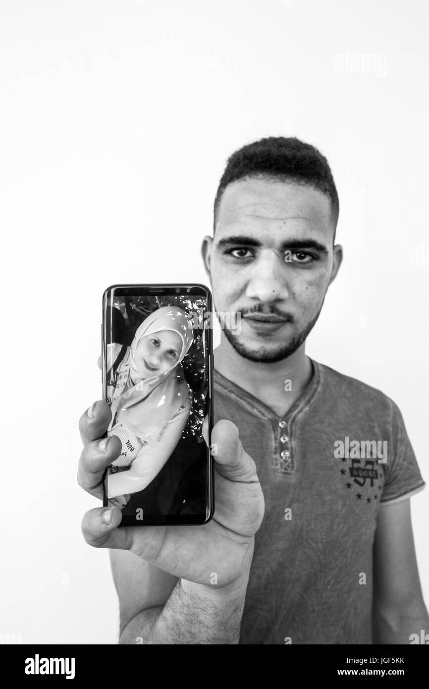 L'Italia, Casorezzo, Khaled mostra la ragazza la foto sullo smartphone Foto Stock