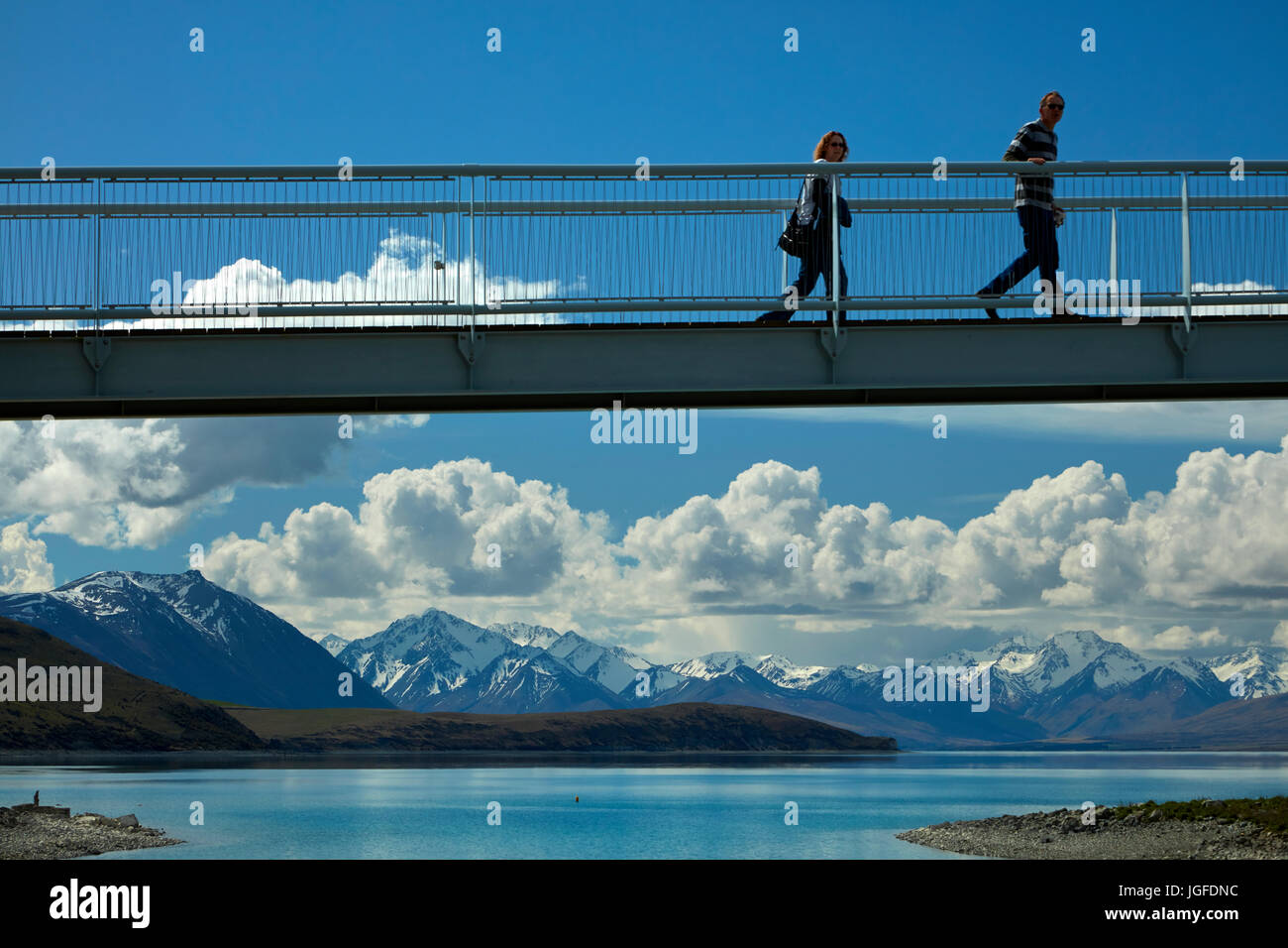 I turisti sul ponte pedonale sul Lago Tekapo uscita verso la Chiesa del Buon Pastore, Mackenzie Country, Canterbury, Isola del Sud, Nuova Zelanda Foto Stock