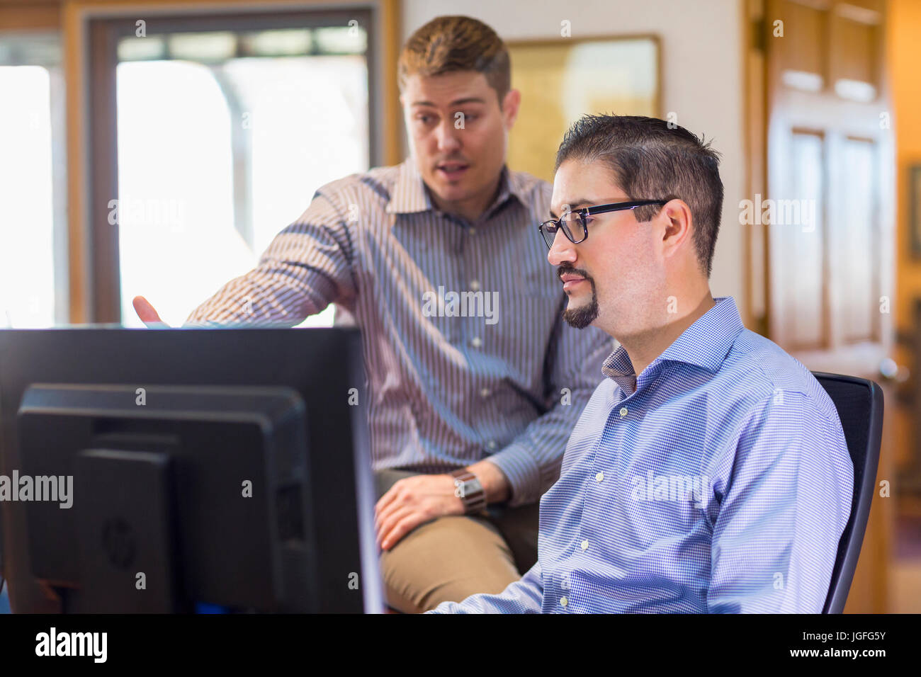 Imprenditori parlando vicino al computer in ufficio Foto Stock