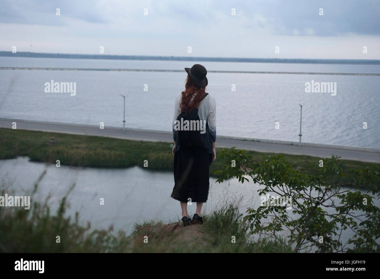 Caucasian woman standing su roccia ammirando ocean Foto Stock