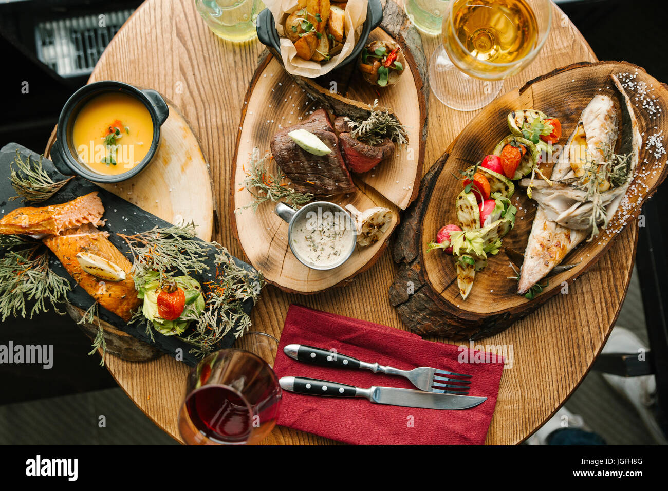 Varietà di carne e pesce sulla tavola con il vino Foto Stock