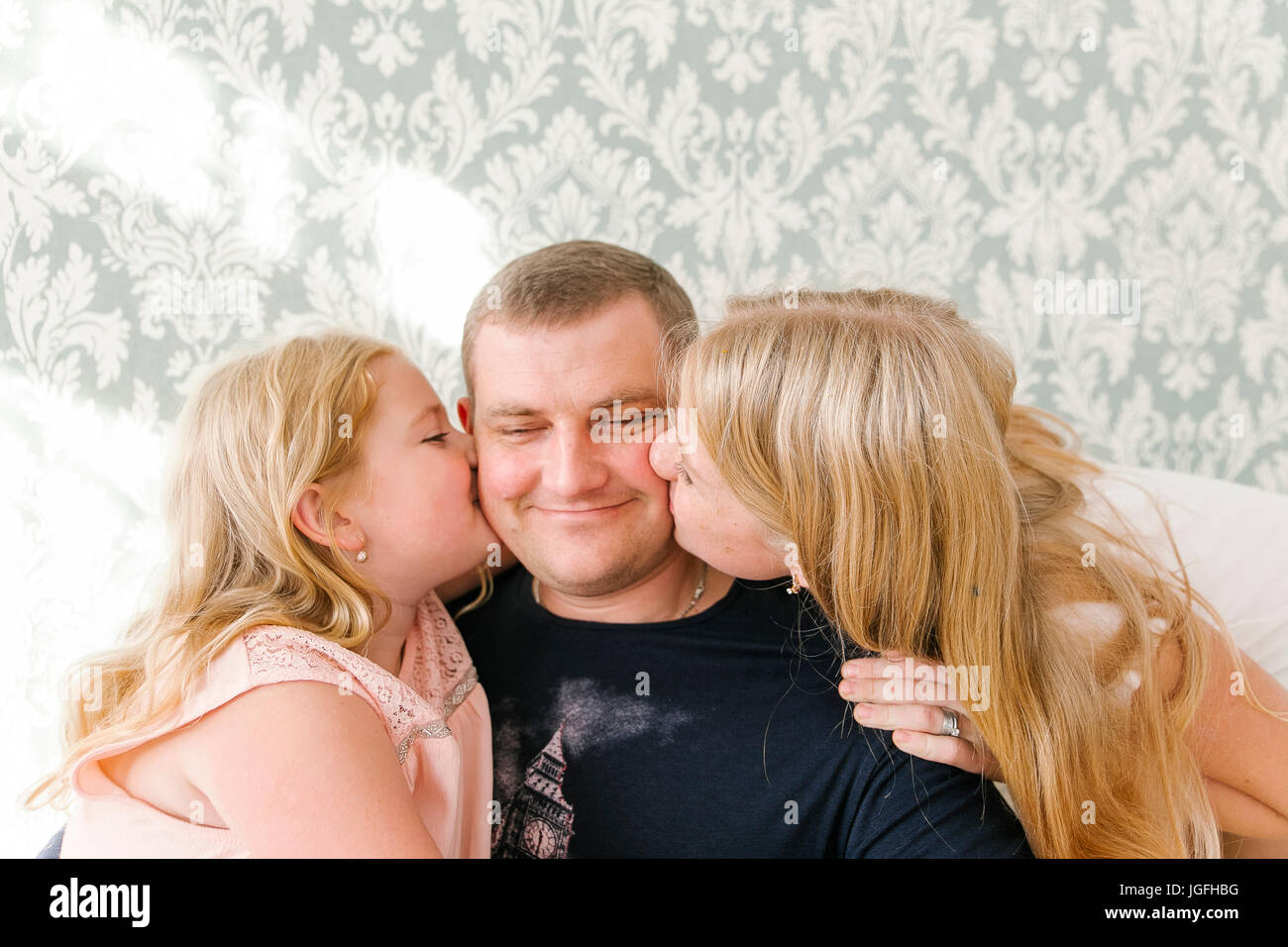 In Medio Oriente le figlie kissing padre sulla guancia Foto Stock